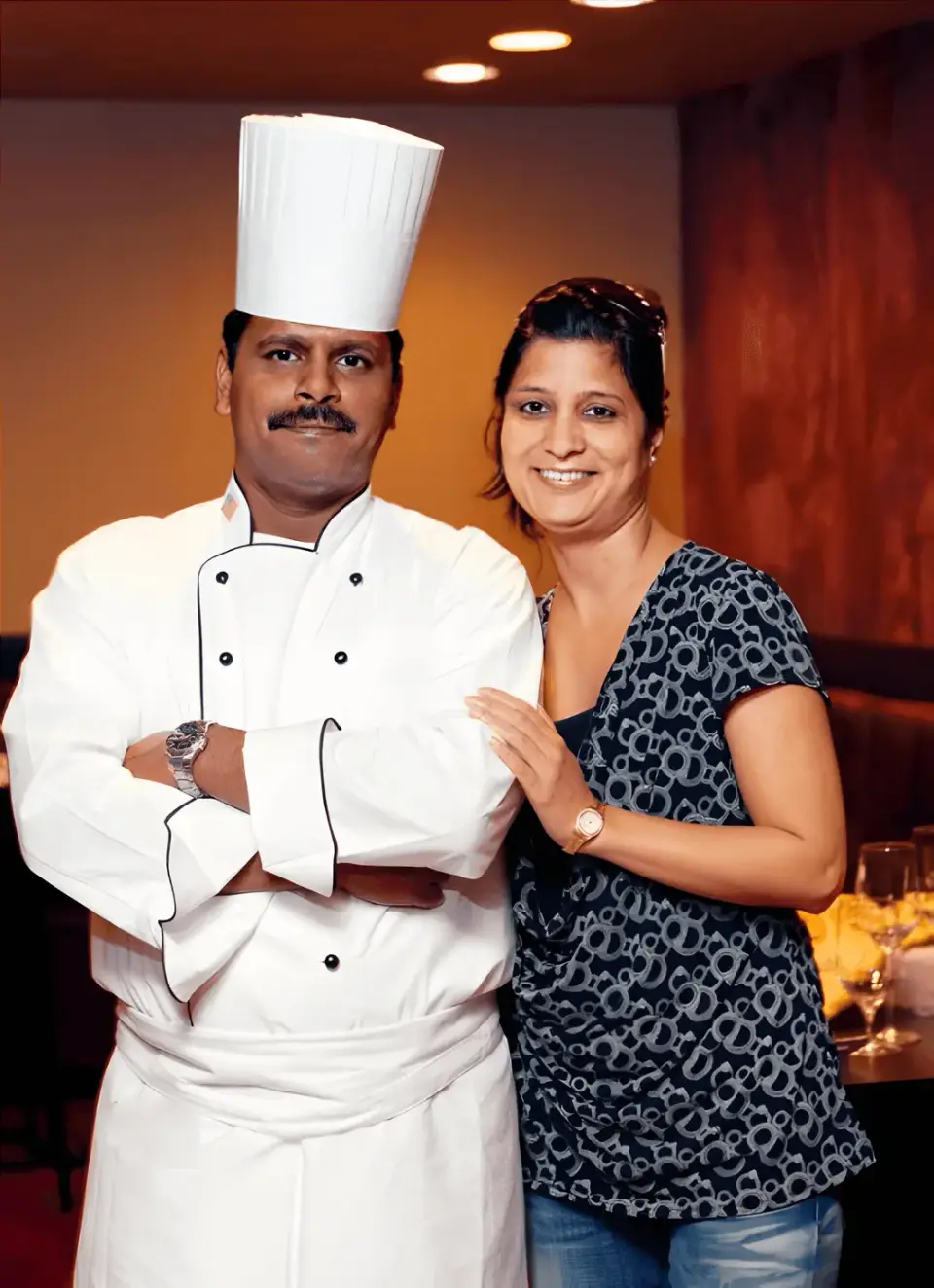 Saffron chef in whites standing with a member of the team