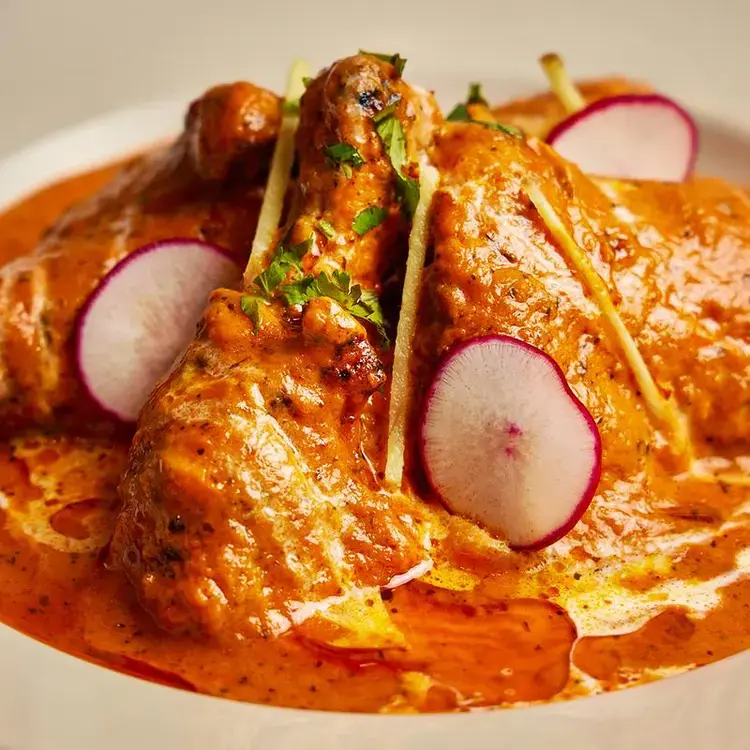 Chicken tikka masala topped with sliced radish